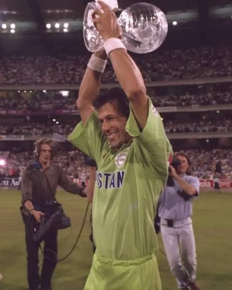 a man holding up a trophy in front of a crowd