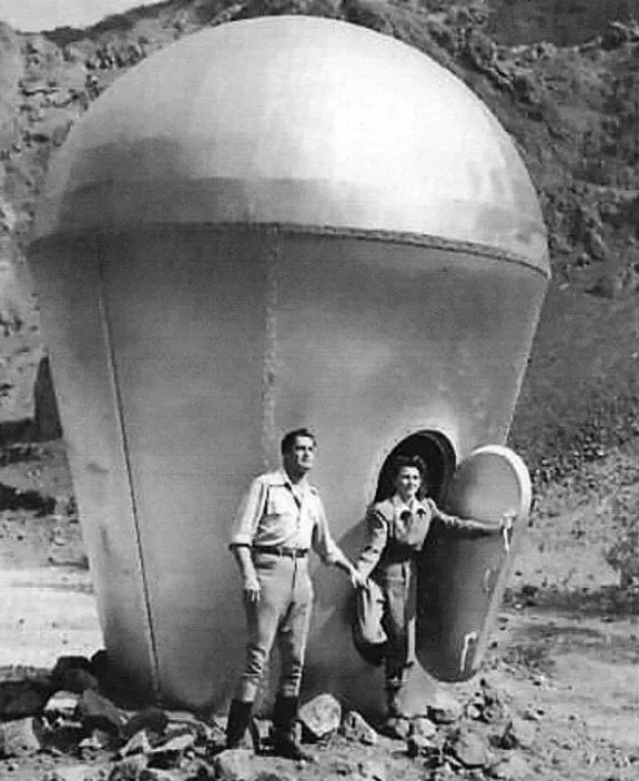 a couple of men standing next to a large object