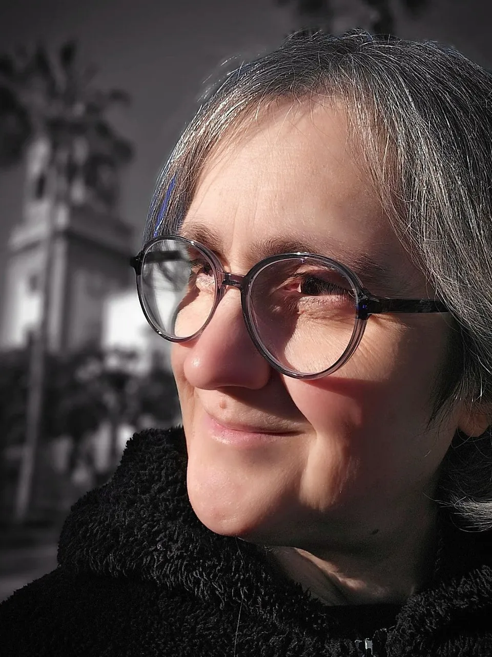 a woman wearing glasses and a black coat