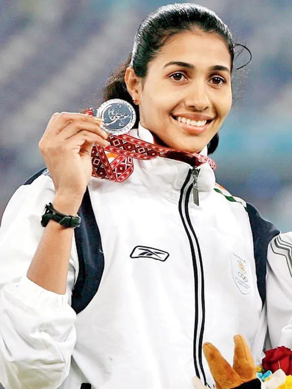 a woman holding a medal and a stuffed animal