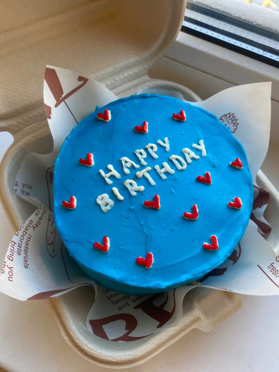 a blue birthday cake with hearts on it