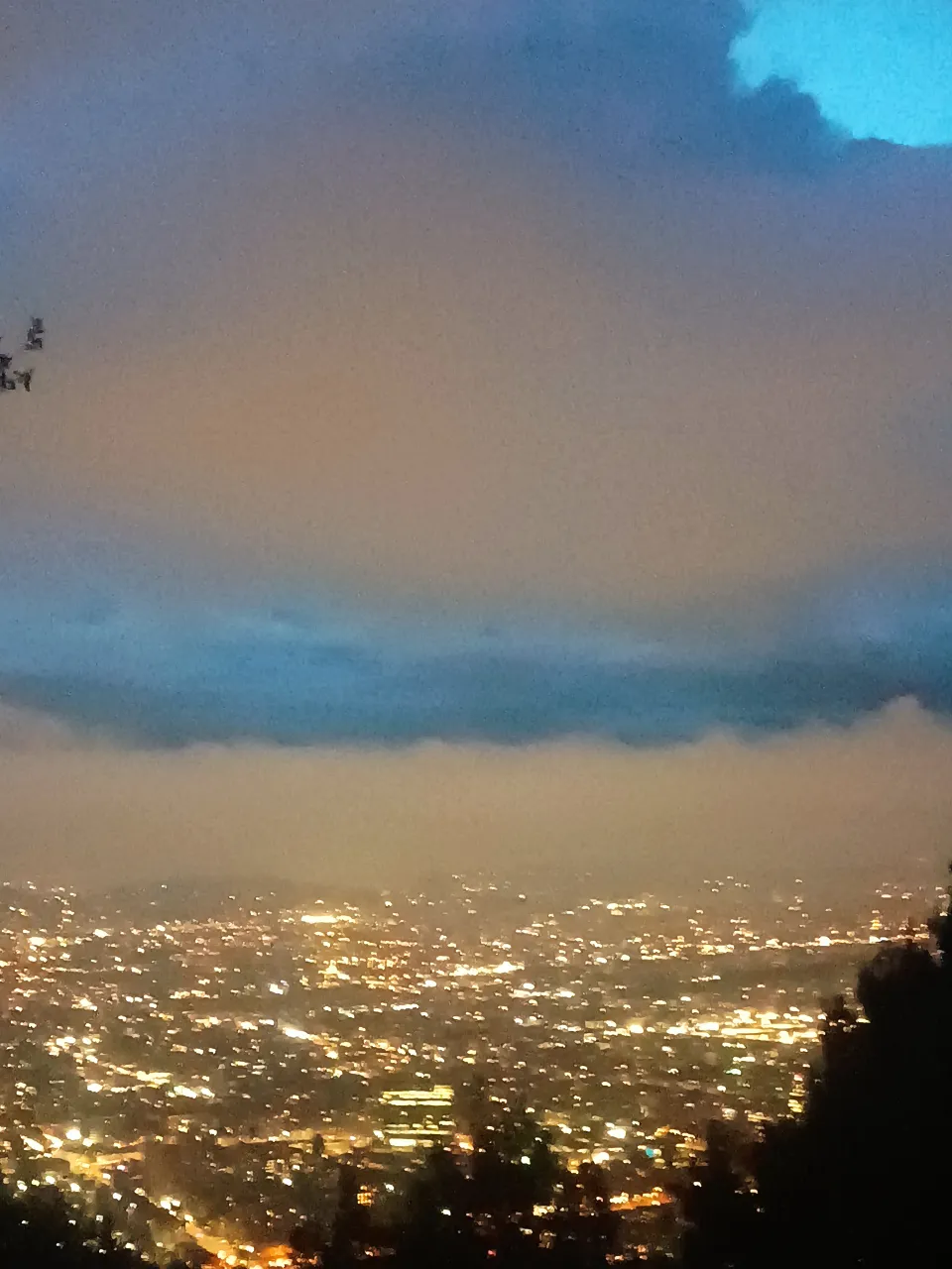 a view of a city at night from a hill