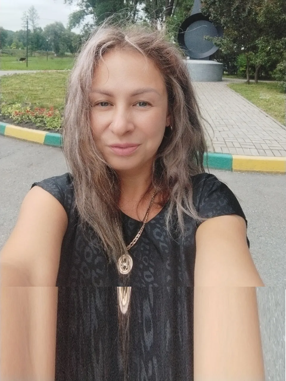 a woman with long gray hair is taking a selfie and smile