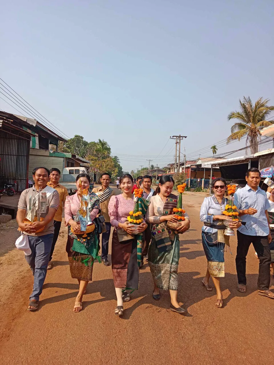 a group of people walking down a dirt road