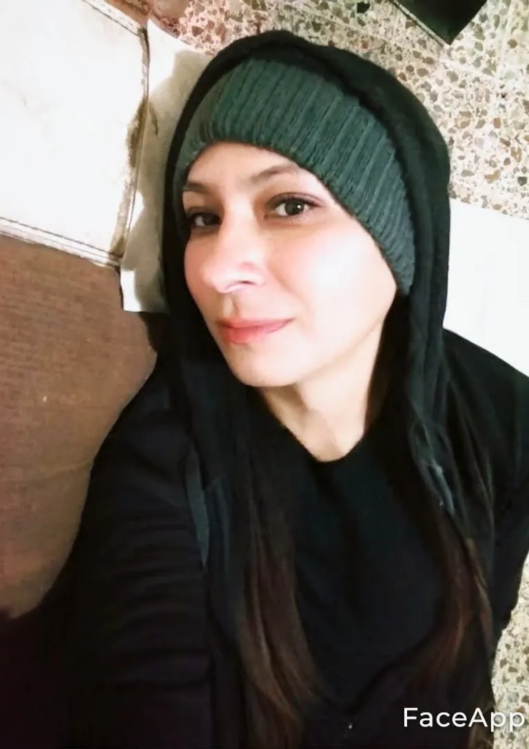 a woman wearing a black hoodie and a green hat