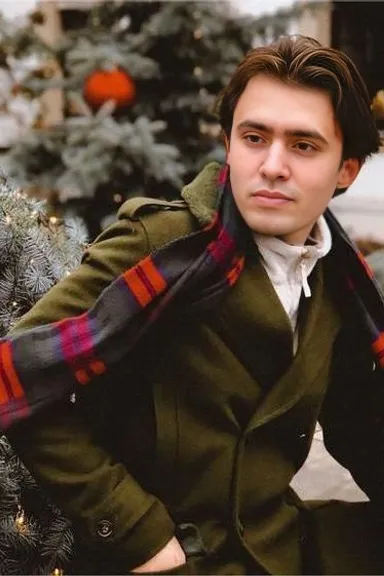 a man in a green coat is posing for a picture