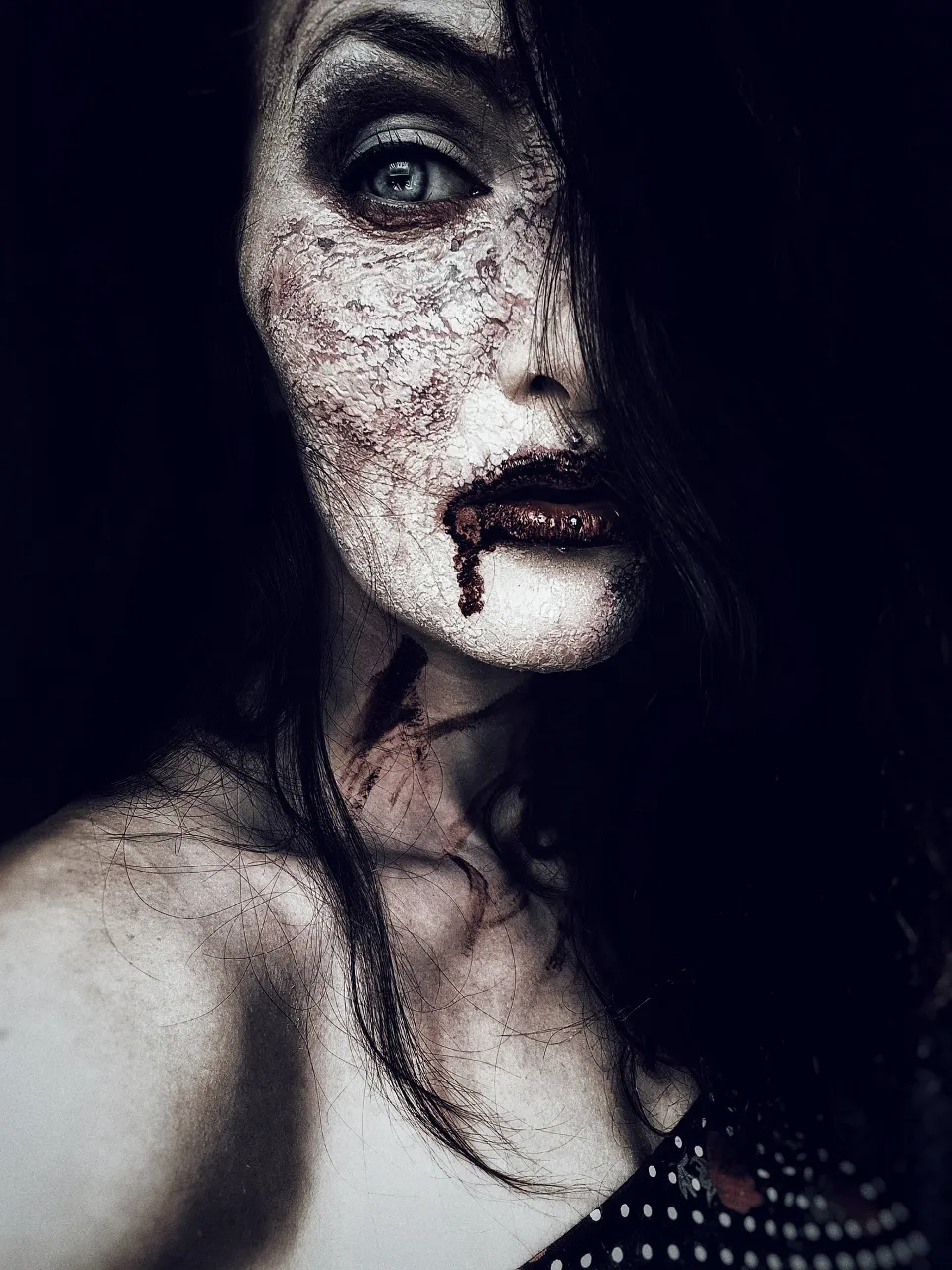 a woman with makeup and blood on her face