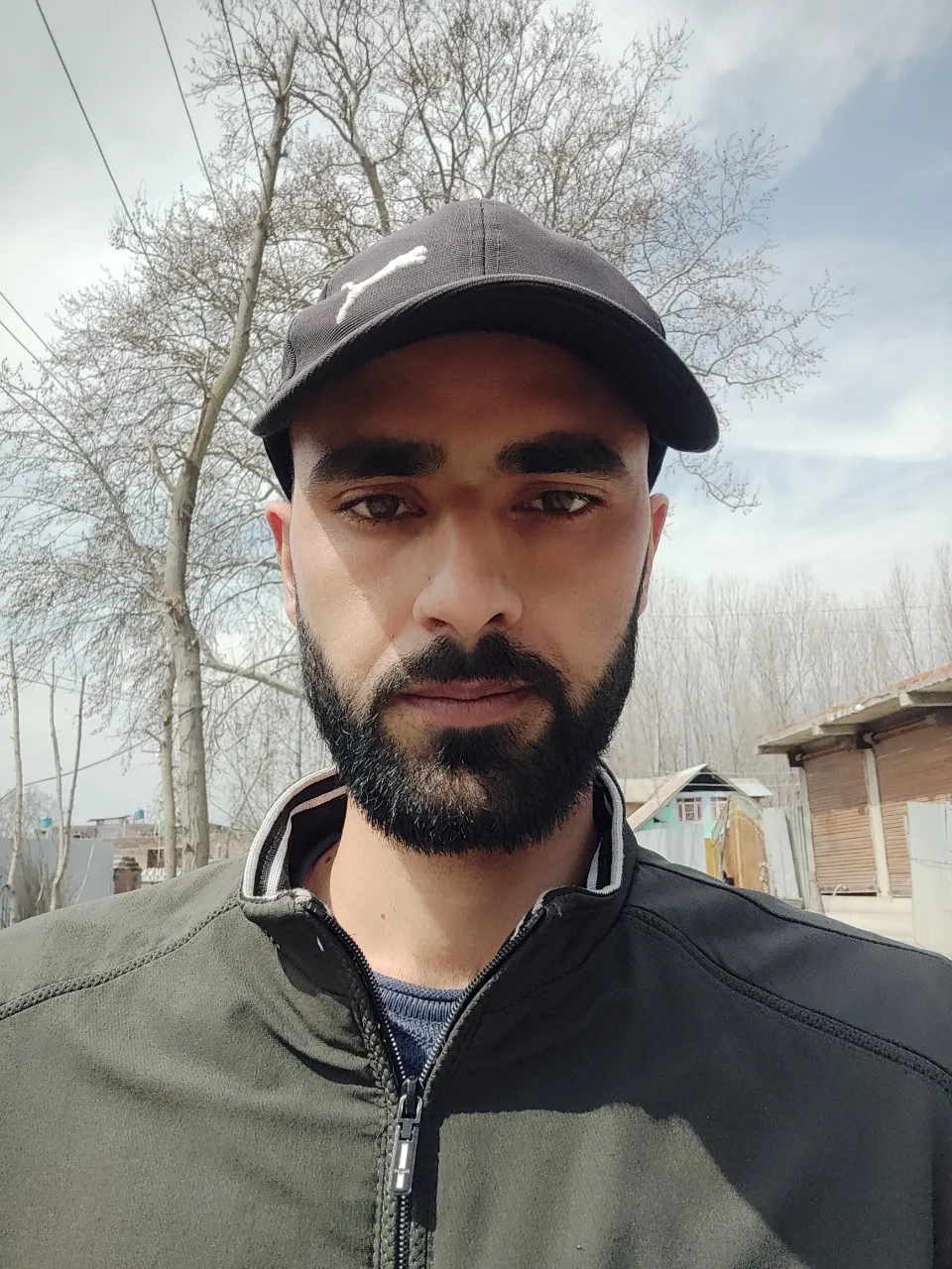 a man with a beard wearing a baseball cap