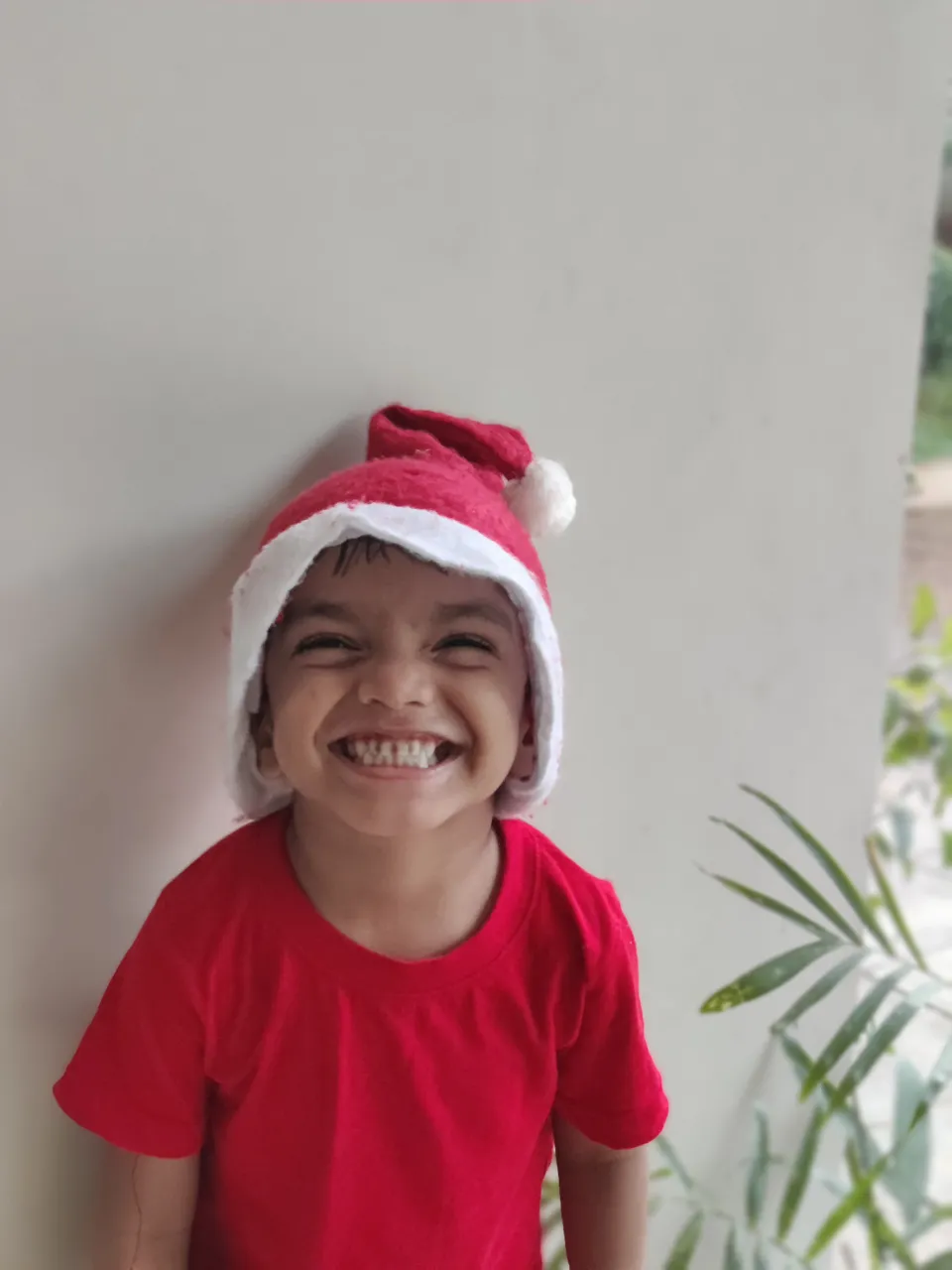 a little boy wearing a santa hat and smiling