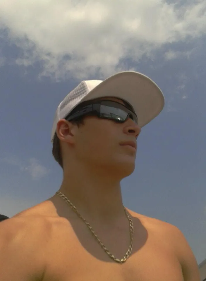 a man wearing neckless and cap and sunglasses