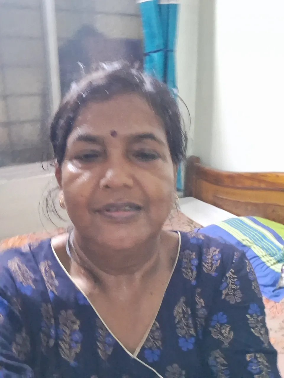 a woman sitting on a bed looking at the camera