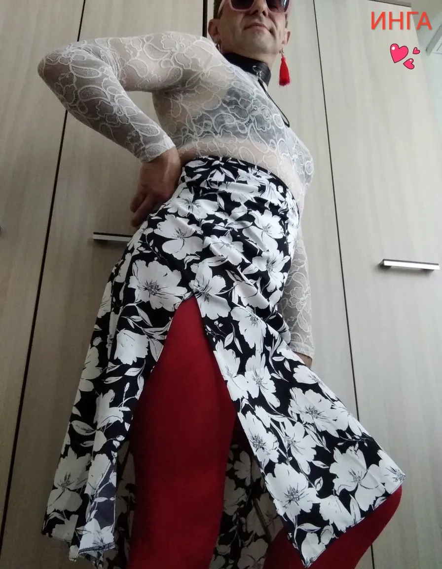 a man wearing a big maxi skirt and a top with flowers on it