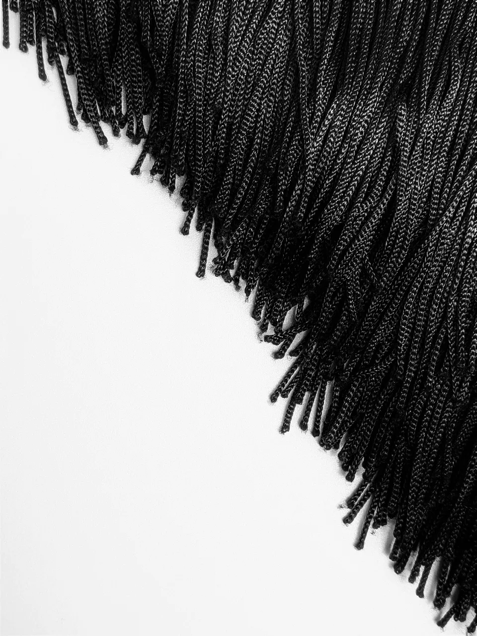 a close up of a black fringe on a white background