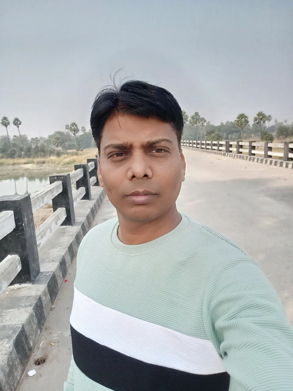 a man standing in front of a wooden fence