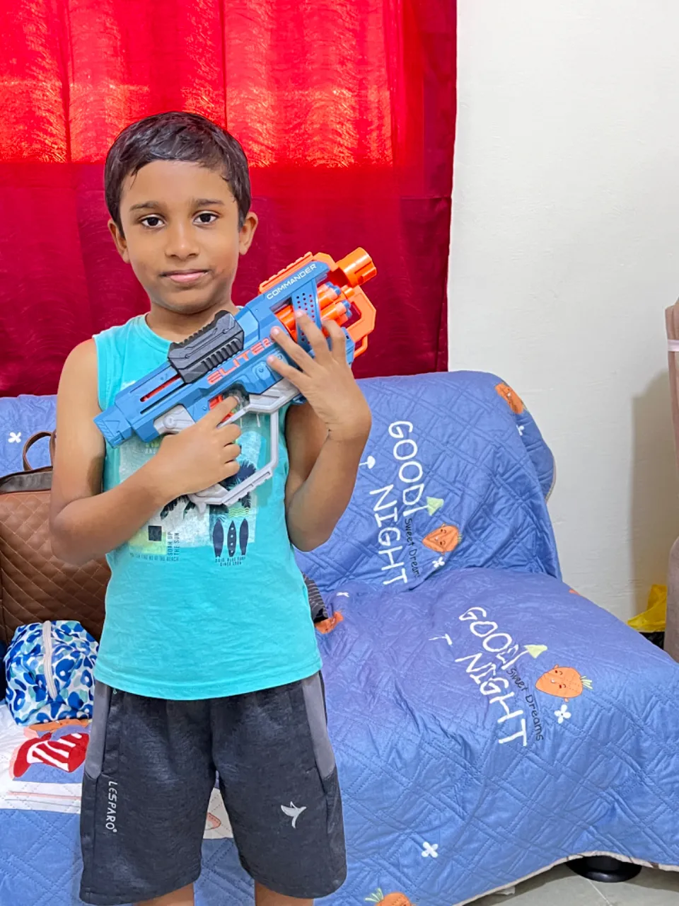 a young boy holding a toy gun in his hands