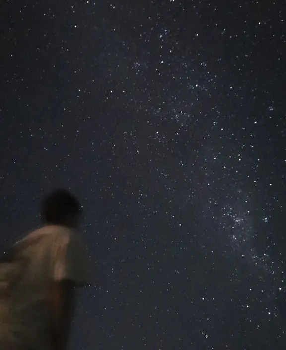 a blonde boy looking up at the stars in the sky