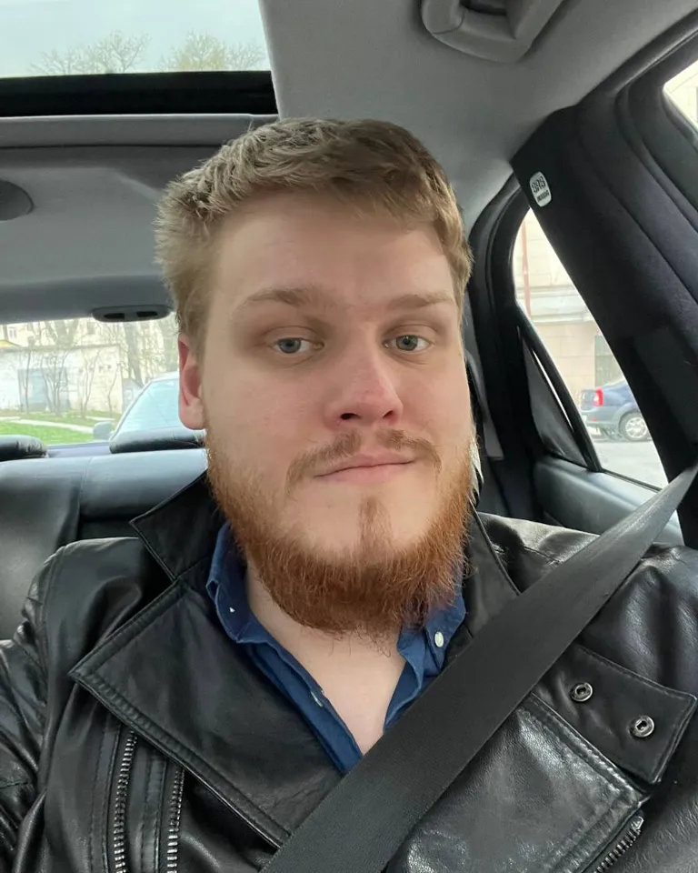 a man with a beard sitting in a car