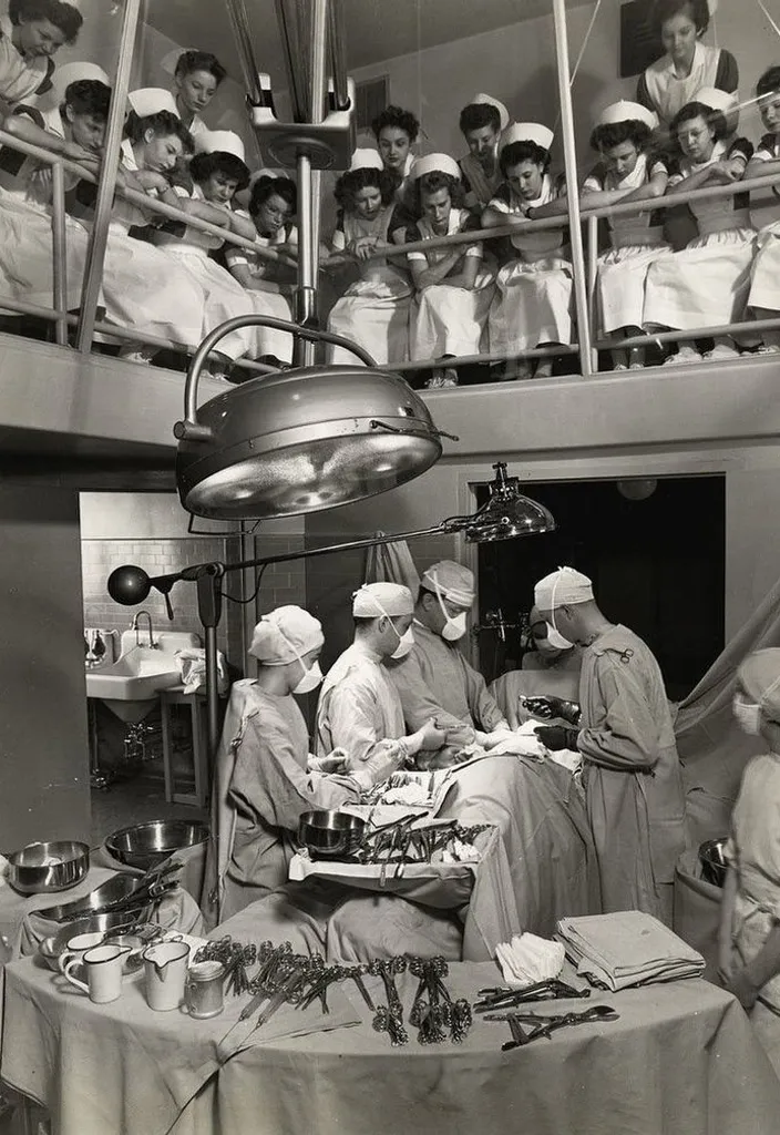 a black and white photo of nurses in a hospital doing surgery 