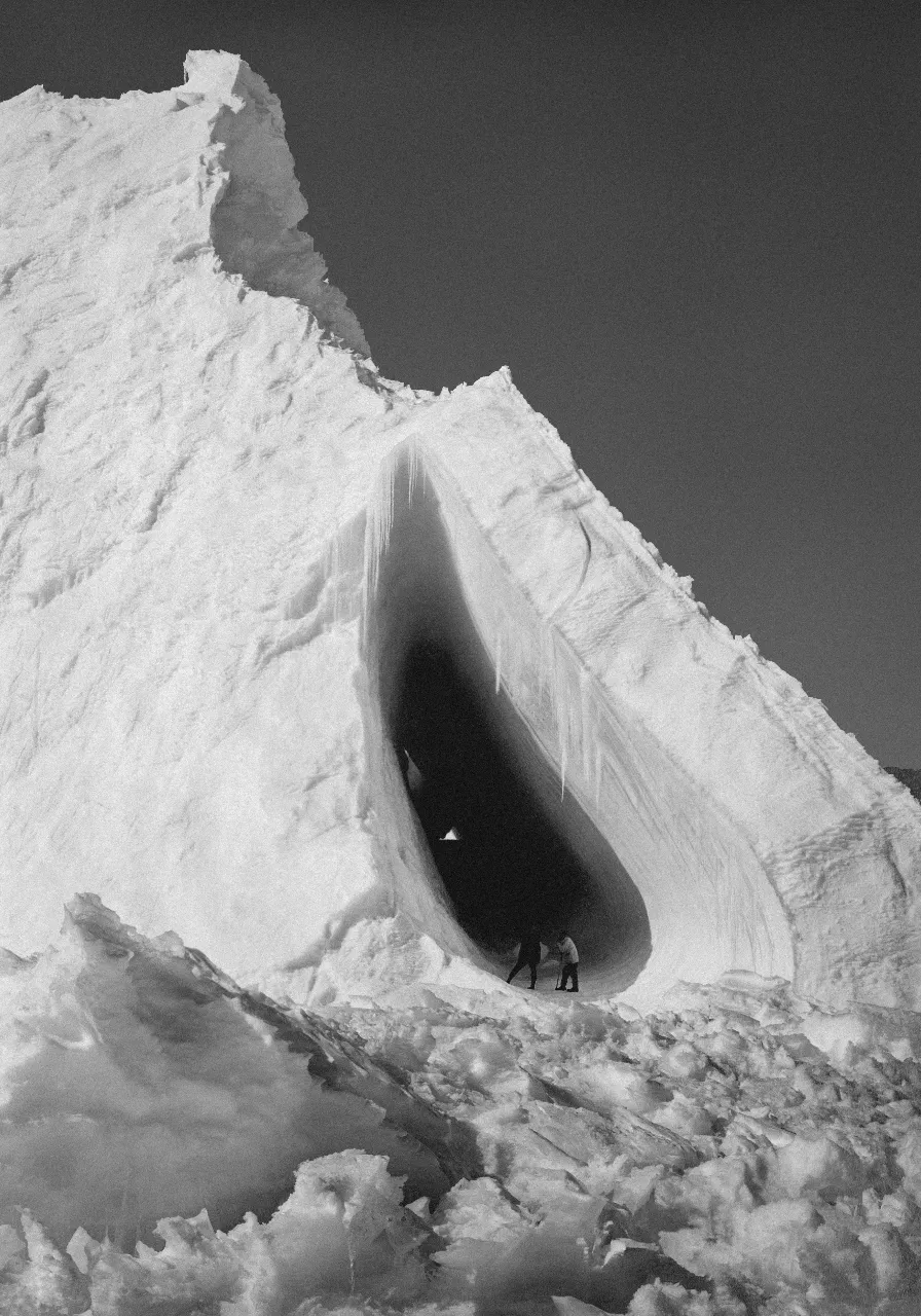 a man standing in an ice cave on top of a mountain