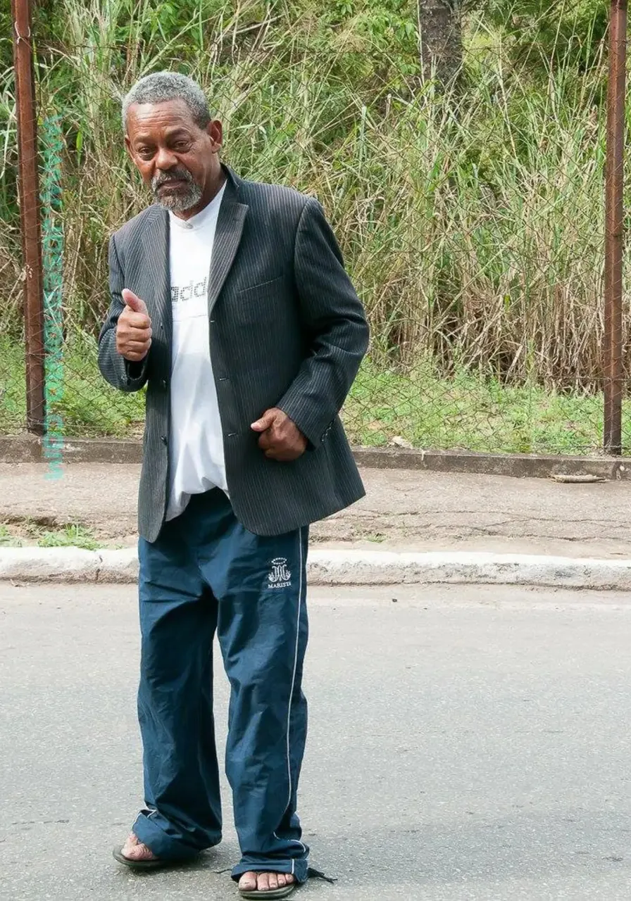 an older man standing on the side of the road