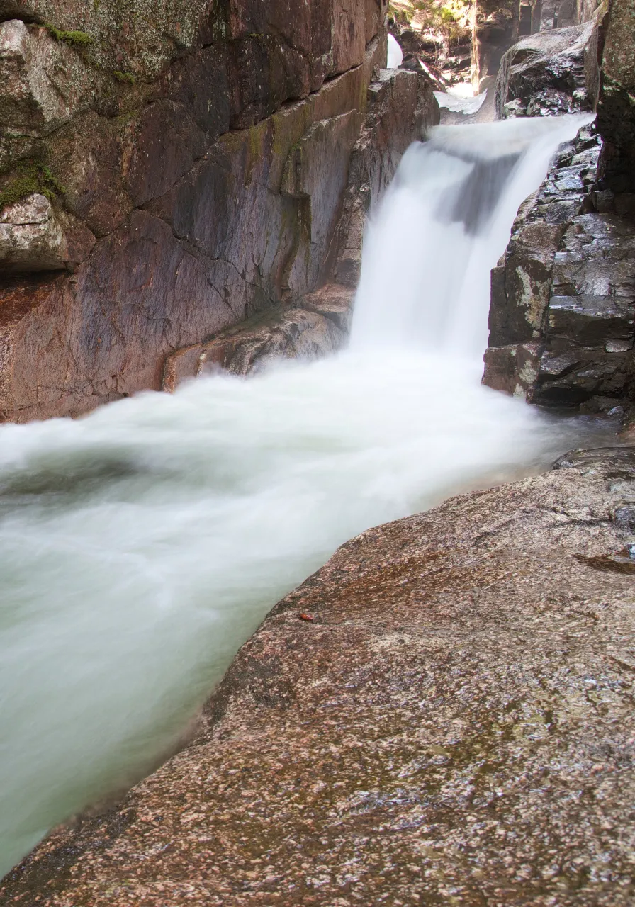 a waterfall flowing down a rocky cliff into a body of water