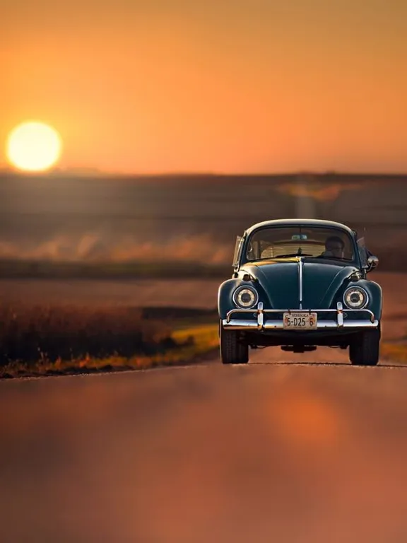 a car driving down a road at sunset