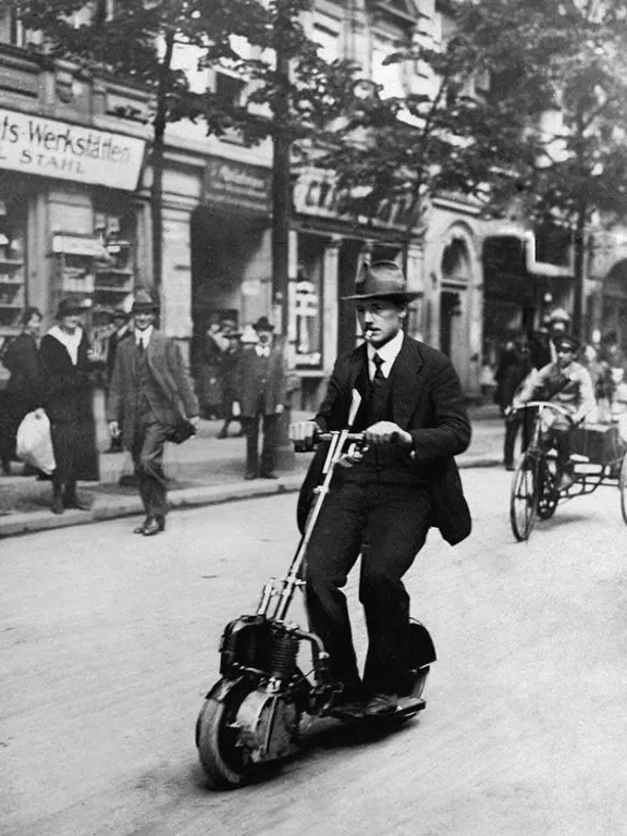 a man riding a scooter down a street