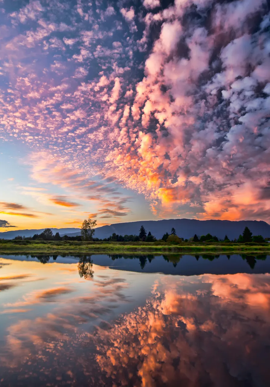 a beautiful sunset with clouds reflecting in the water