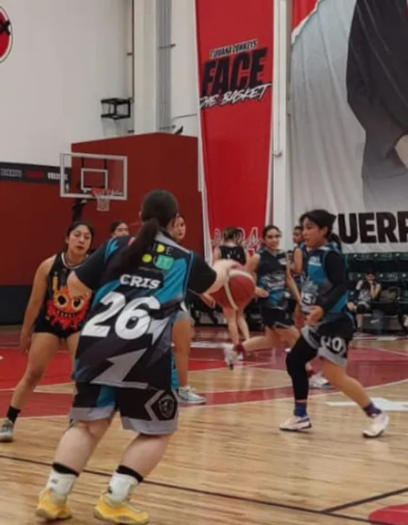 a group of young women playing a game of basketball