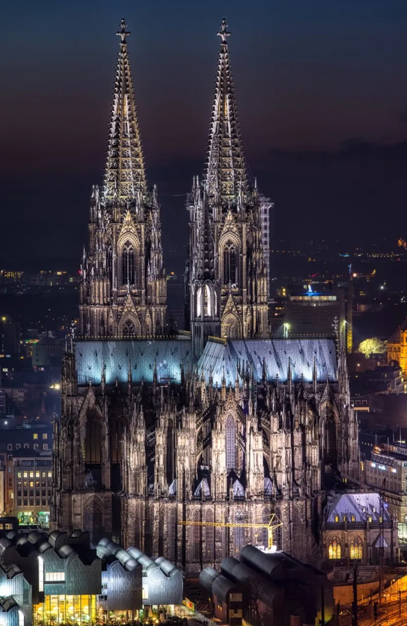 a large cathedral lit up at night in a city