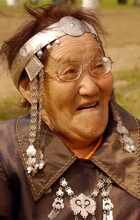 an old woman with glasses and a head piece kazakh