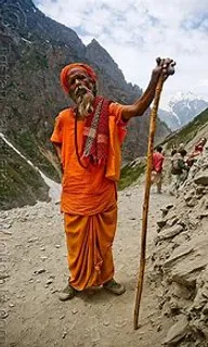 a man in an orange outfit holding a stick