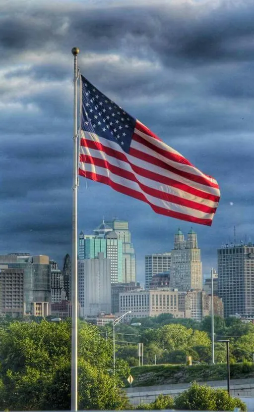 an american flag flying in front of a city skyline