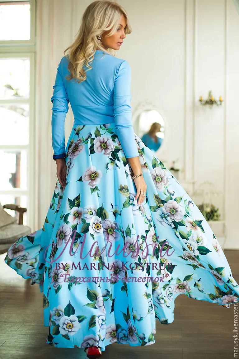 a woman in a blue dress standing in a room