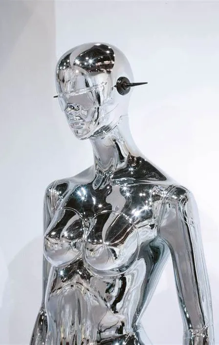 a silver statue of a woman with a cigarette in her mouth