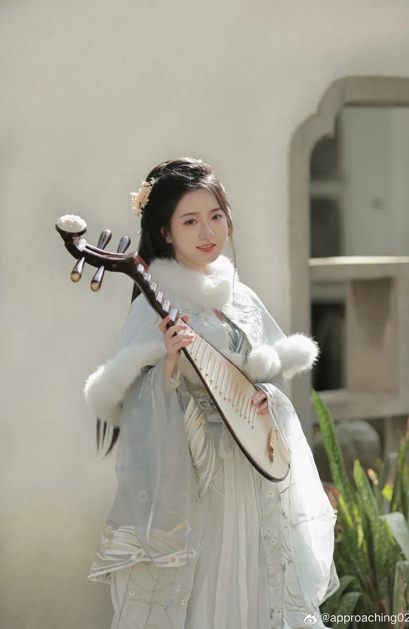 a woman in a white dress holding a musical instrument