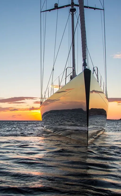 a sailboat in the water at sunset