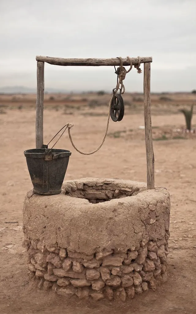 a well in the middle of a dirt field