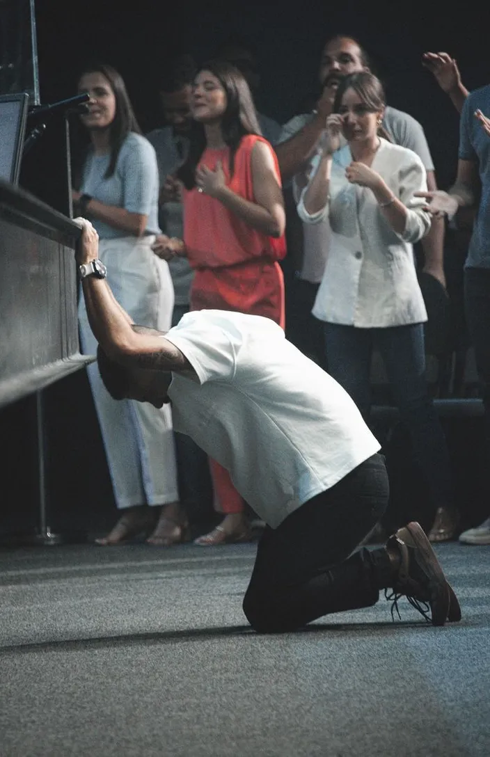 a man kneeling down in front of a crowd of people