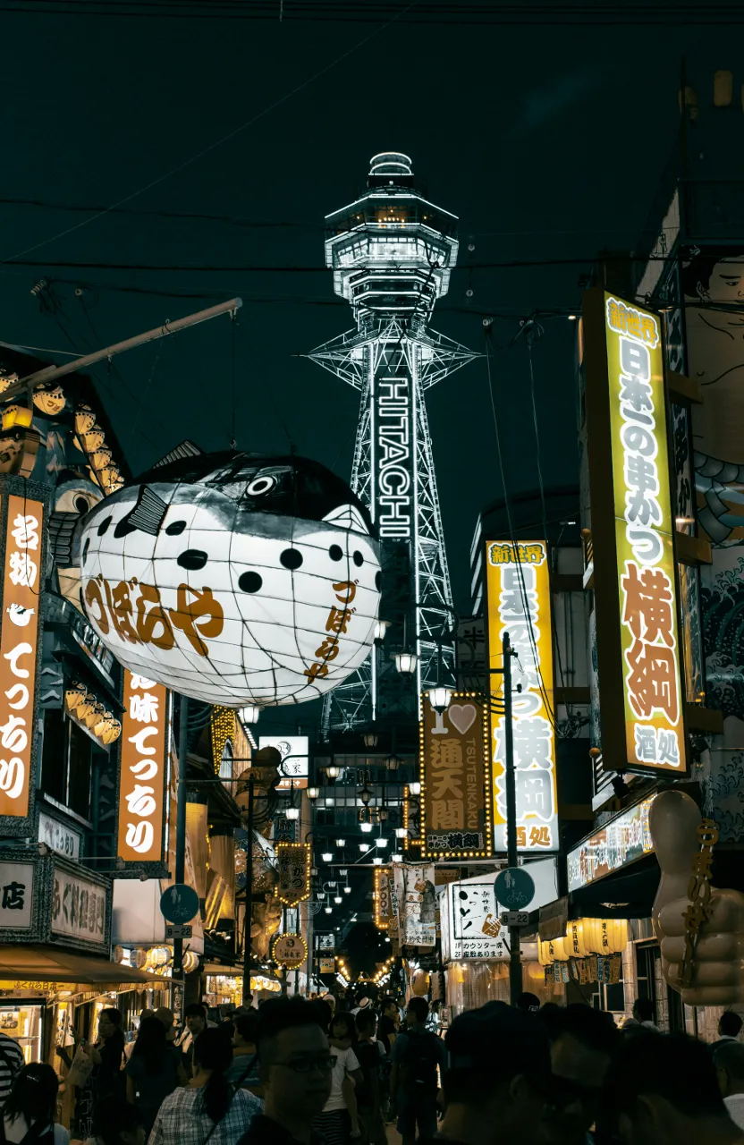 a large hello kitty sign hanging from the side of a building  in Oasaka Japan