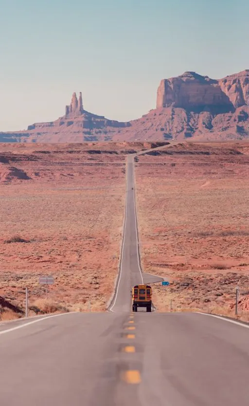 a truck driving down the middle of a desert road