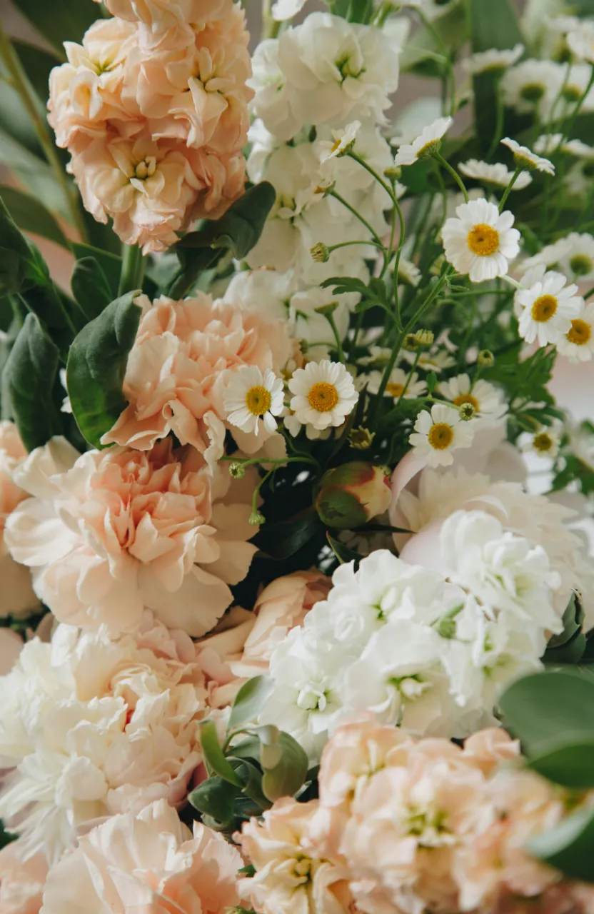 Flower bouquet held by hand, backlit by a shimmering, serene waterside scene