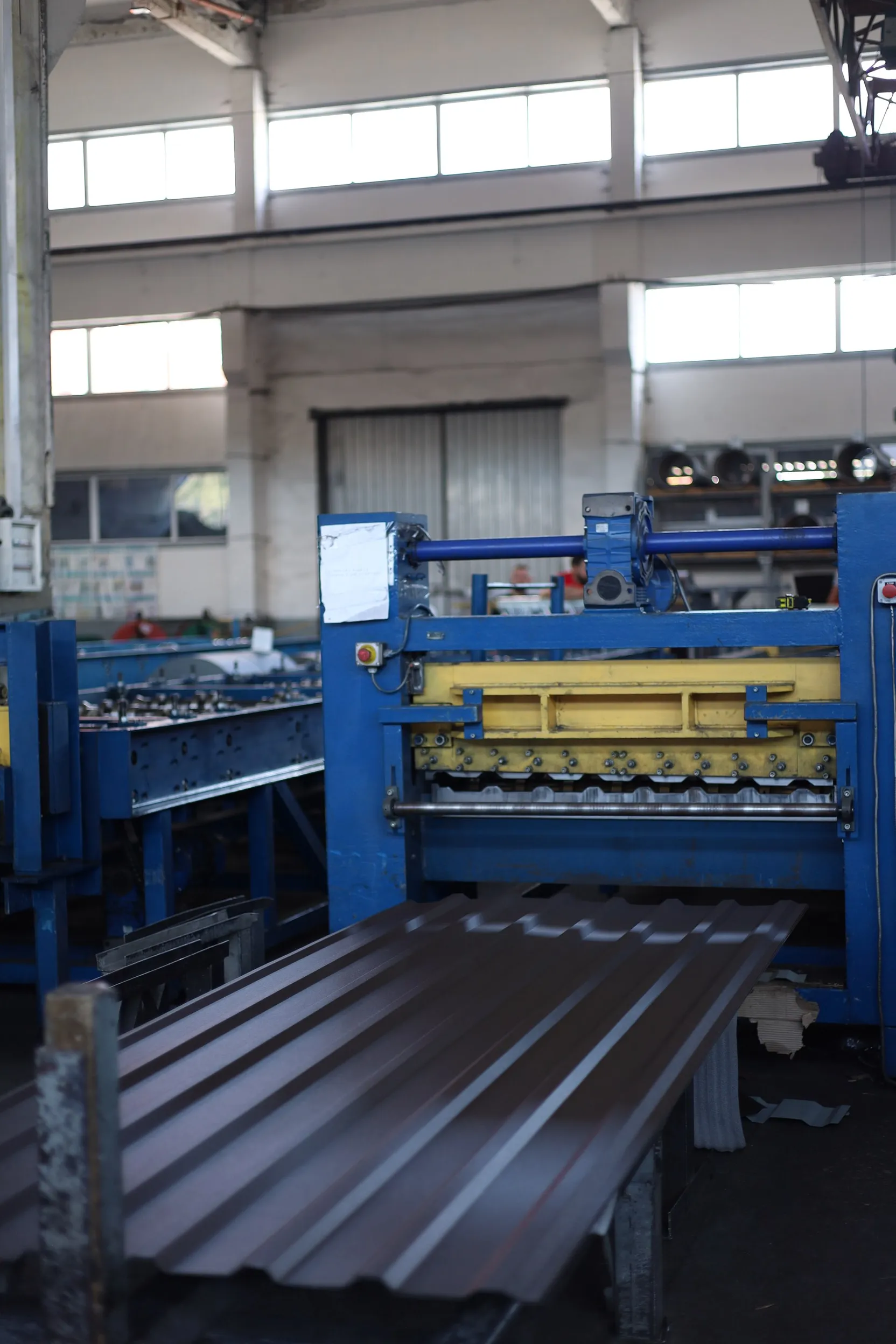 an employee of a company engaged in the production of roofing materials makes flat metal tiles, the employee is dressed as Superman, advertising style