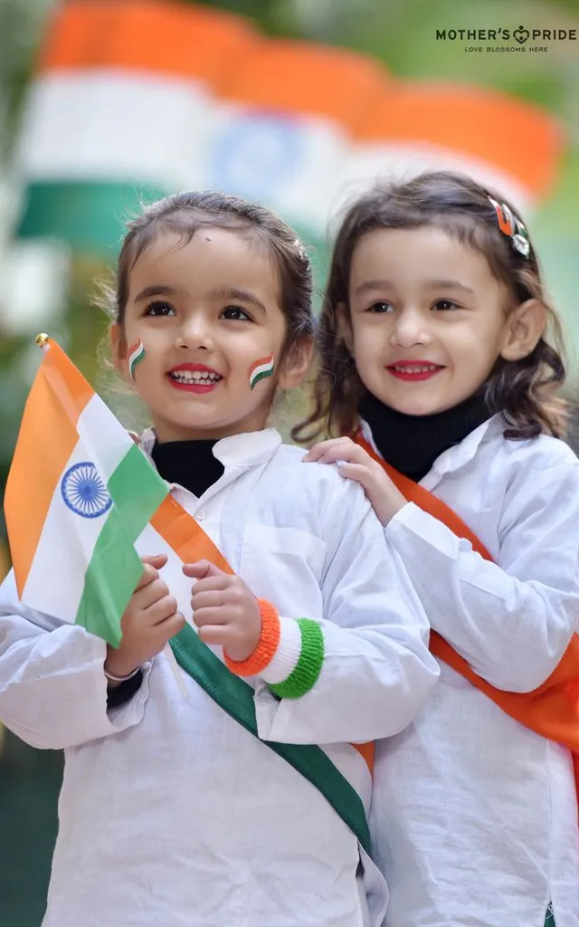 Two young girls holding flags cheering on runners in a marathon