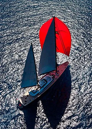 a red and black sail boat in the ocean