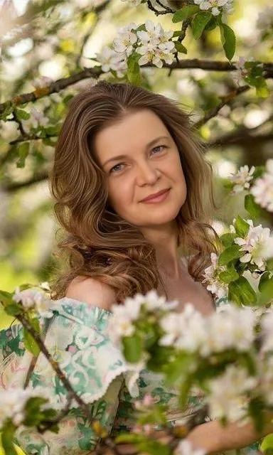 a woman standing in a tree with white flowers