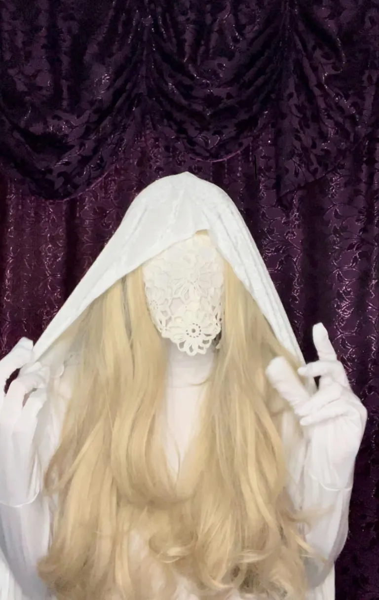 a woman with long blonde hair wearing a white veil