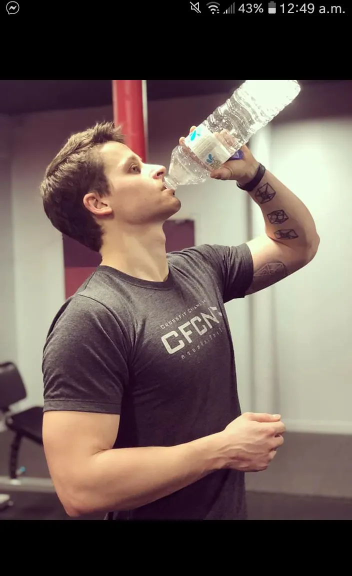 a man drinking water from a water bottle