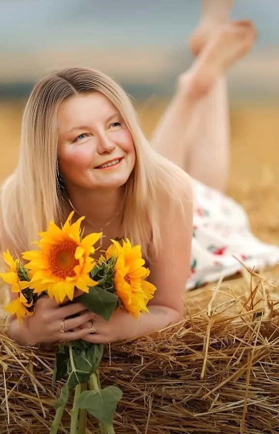 a woman laying on the ground with a bunch of sunflowers