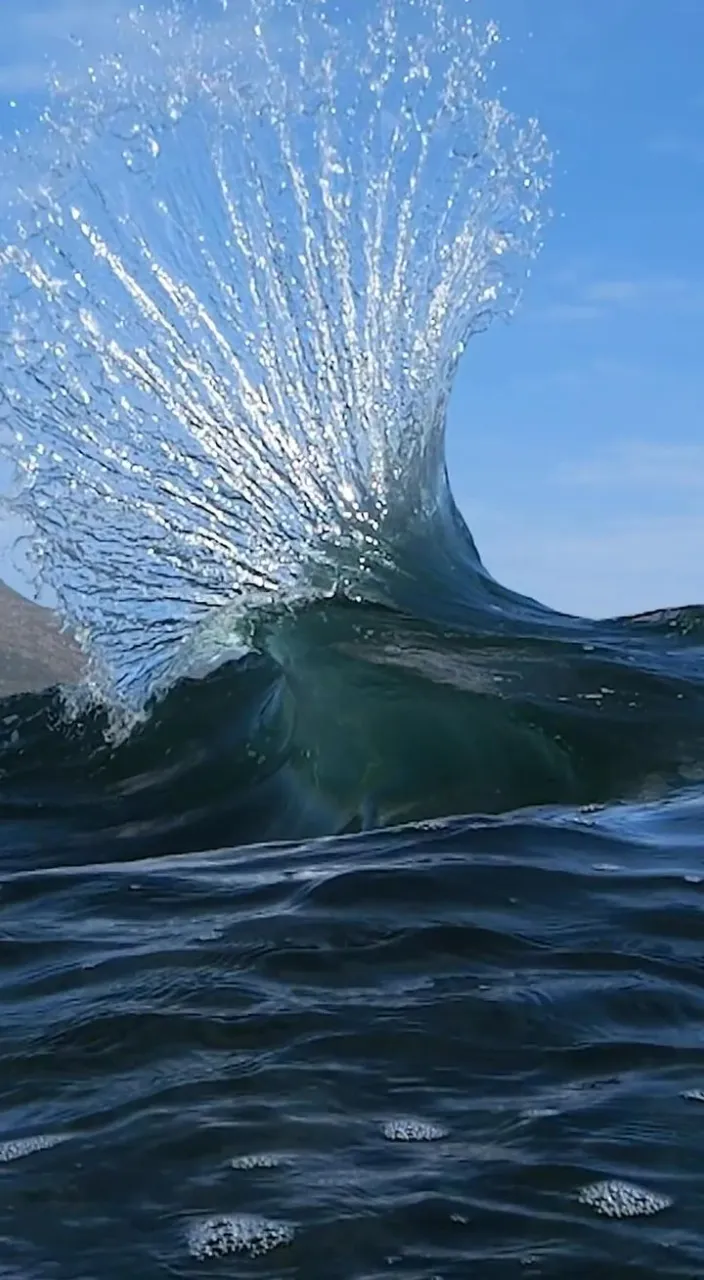 a large wave is crashing into the ocean